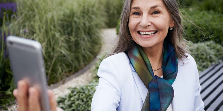 Woman smiling and holding phone in selfie position