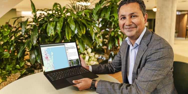 Suncorp employee smiling for camera showing laptop