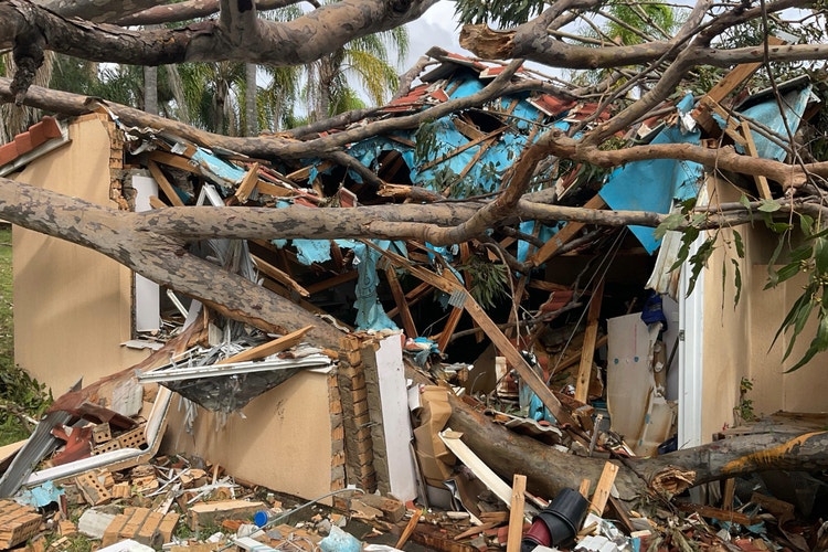 Suncorp disaster hub parked by side of the road with customers chatting to Suncorp staff at white table.