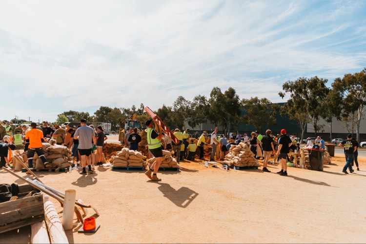 group of workers carrying sandbags and equipment