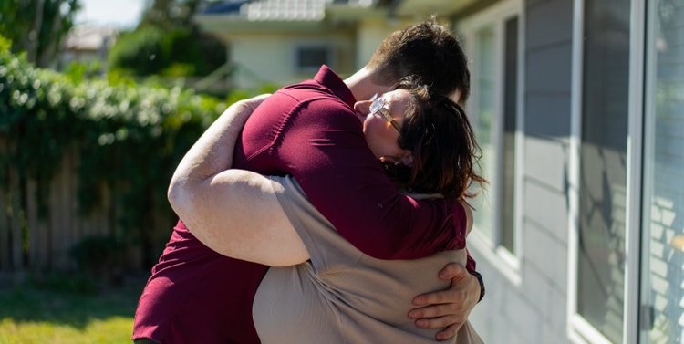 Mary and Joey hugging in her front garden