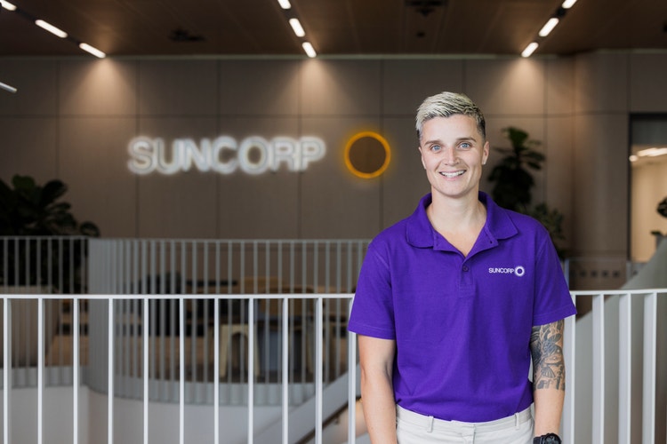 woman wearing purple Suncorp polo in office