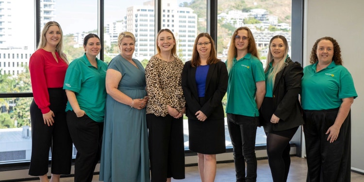 group of office workers in Suncorp polos standing in front of glass window