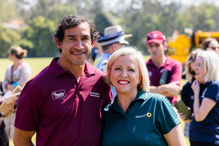 man wearing get ready shirt and woman wearing suncorp polo posing for camera