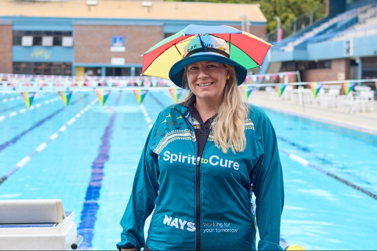 woman standing outside swimming pool wearing spirit to cure jacket