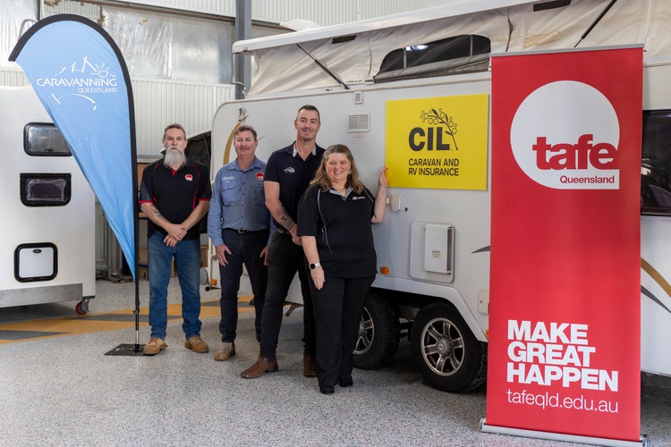 group photo outside caravan and and CIL sign