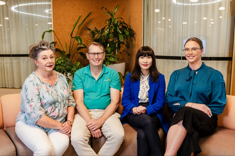 group of suncorp employees sitting on couch in office