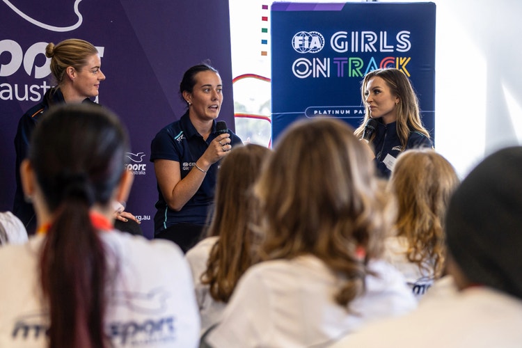 speakers in front of Fia Girls on Track sign