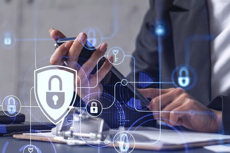 person holding phone with cybersecurity symbols floating in the air