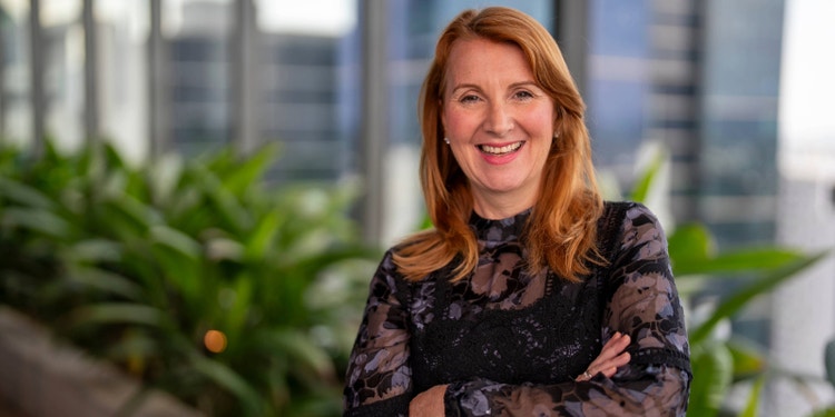 woman wearing black blouse smiling at camera in office garden