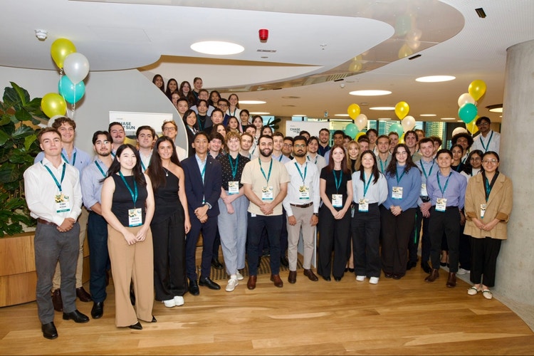 large group photo of Suncorp graduates standing round in office
