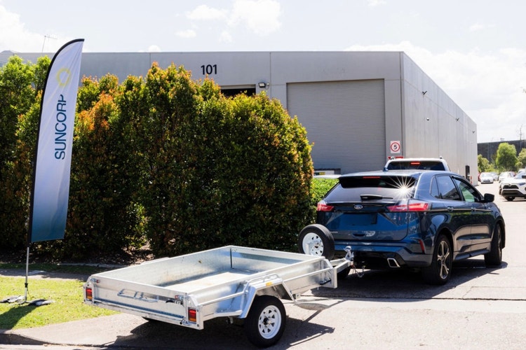 car drink up commercial driveway past Suncorp sign