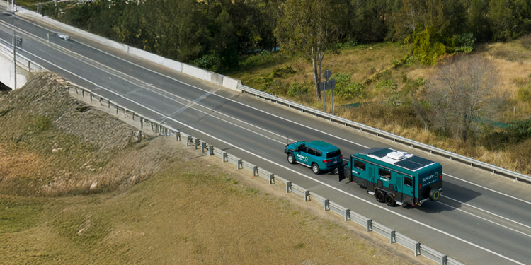 aerial shot of suncorp green caravan driving along highway