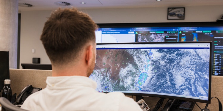 man reviewing radar loop on computing while sitting