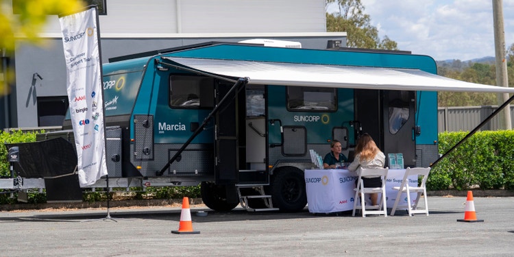 suncorp mobile disaster hub sitting in suburb with claims oficer speaking to customer sitting at table