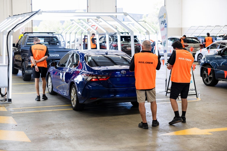 Hail assessment crew in assessment centre inspecting vehicles
